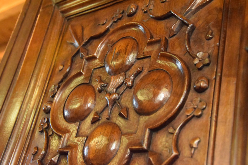 Porte sculptée, quadrilobe à besants avec cœur fléchés et fleurs de lys
